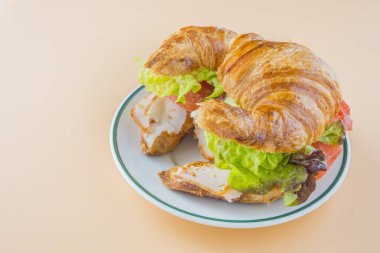 Sandviç kruvasan, marul, domates ve füme hindi.