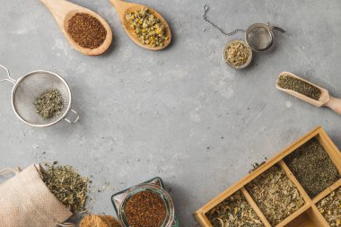 Gri arka planda tahta kaşıklı otlar.