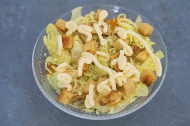 Tostlu Sezar salatası, marul ve tipik soslu kızarmış tavuk göğsü.