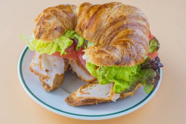 Sandviç kruvasan, marul, domates ve füme hindi.