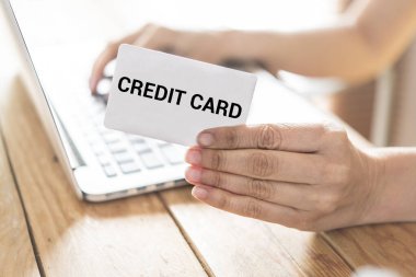 Çevrimiçi alışveriş için kredi kartı kullanan bir adamın en üst görüntüsü