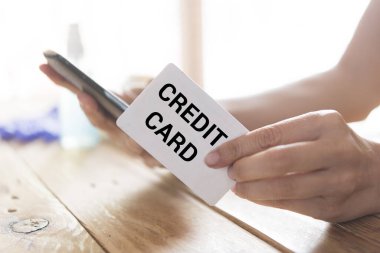 Çevrimiçi alışveriş için kredi kartı kullanan bir adamın en üst görüntüsü