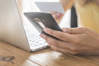 Çevrimiçi alışveriş için kredi kartı kullanan bir adamın en üst görüntüsü