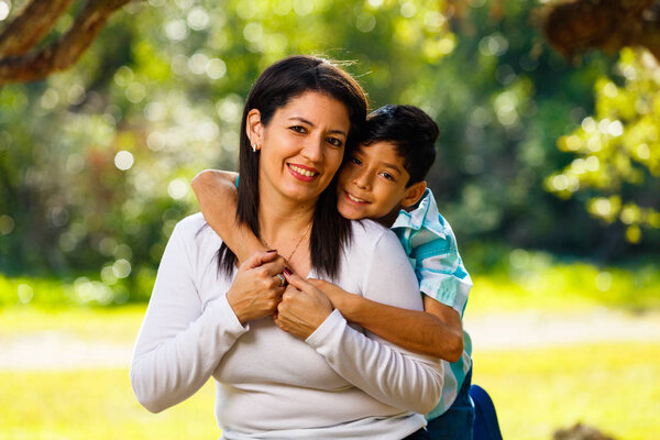 Mother and son outdoor lifestyle portrait in a park setting.