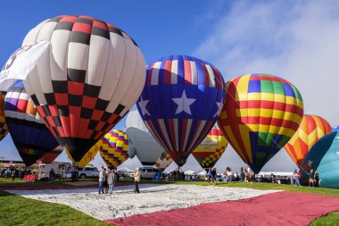 Albuquerque, New Mexico USA - October 5, 2019: Balloonists preparing their colorful hot air balloons for flight at the famous annual Albuquerque Hot Air Balloon Fiesta located in the dedicated Balloon Fiesta Park.