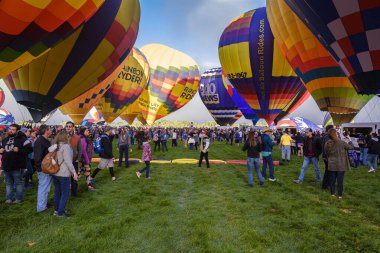 Albuquerque, New Mexico USA - October 5, 2019: Visitors gathered around the colorful hot air balloons preparing for flight at the famous annual Albuquerque Hot Air Balloon Fiesta located in the dedicated Balloon Fiesta Park.