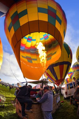 Albuquerque, New Mexico USA - October 5, 2019: Participant entering the basket of a colorful hot air balloon in preparation for flight at the famous annual Albuquerque Hot Air Balloon Fiesta located in the dedicated Balloon Fiesta Park.