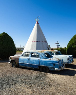 Holbrook, Arizona USA - October 6, 2019: The iconic and vintage Wigwam Motel, a popular tourist destination, with tipi style motel rooms and classic cars along the historic Highway Route 66.