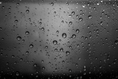Su arka plana düşer. Pencereye yağmur düşer.