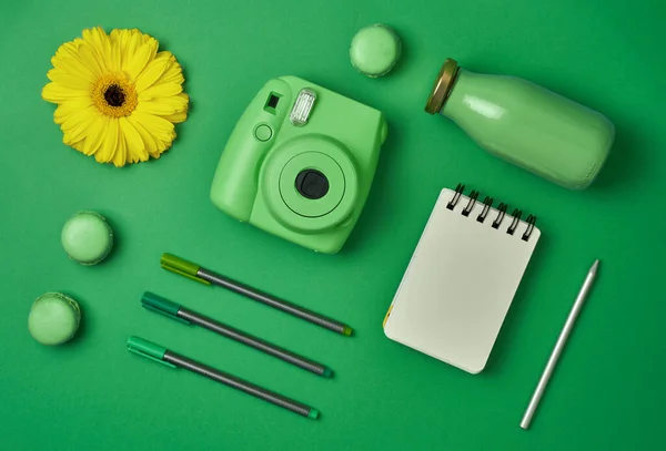 Lápices de cámara y cuaderno sobre fondo verde — Foto de Stock