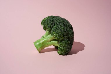 Pembe arka planda yeşil brokoli kafası