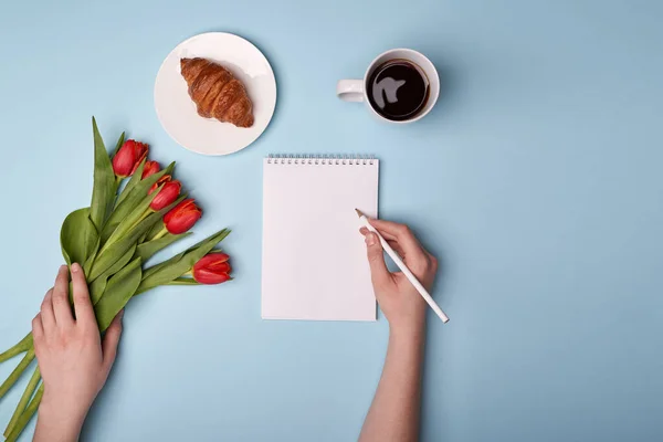 Café, croissant, bloc de notas, bolígrafo, teléfono y flores — Foto de Stock