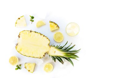 Limonata ananas, limon ve buz düz beyaz zemin üzerinde yatıyordu