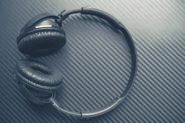 Wireless Headphones on the Carbon Background Closeup. Dark Grey