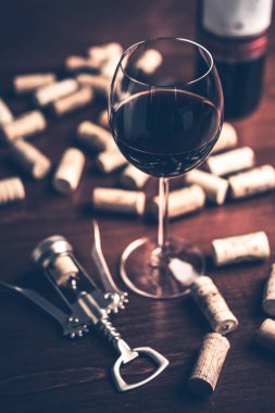 Kırmızı şarap cam, mantarlar ve tirbuşon ahşap tablo.