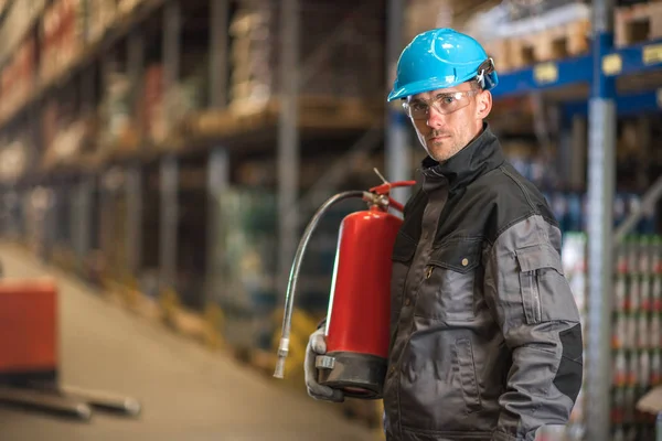 Trabalhador do armazém caucasiano com extintor de incêndio — Fotografia de Stock