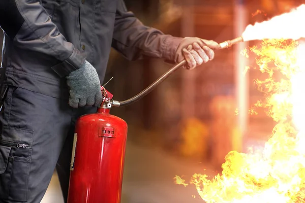 Hombre con extintor de incendios lucha contra el fuego foto de primer plano . — Foto de Stock