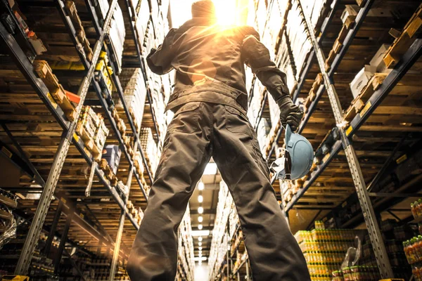 Працівник з шоломом стоїть перед сучасним складом . — стокове фото