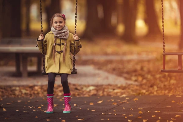 Salıncaktaki mutlu genç kız. Sonbahar teması.