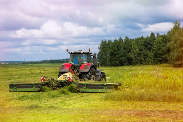 Un tractor corta hierba en el campo . —  Fotos de Stock