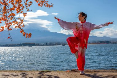 Wushu 'daki Japon kız volkanın arka planında poz veriyor. 