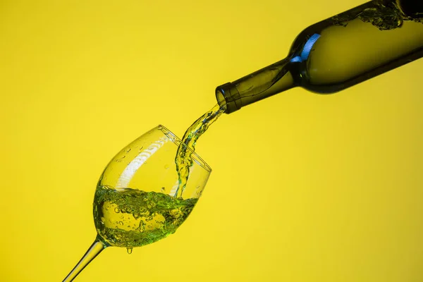 Біле вино наливають у склянку . — стокове фото