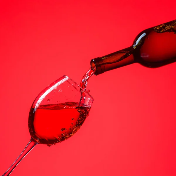 Rode wijn wordt in een glas gegoten. — Stockfoto