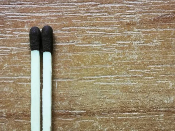 5G tie lined with matches on a wooden table
