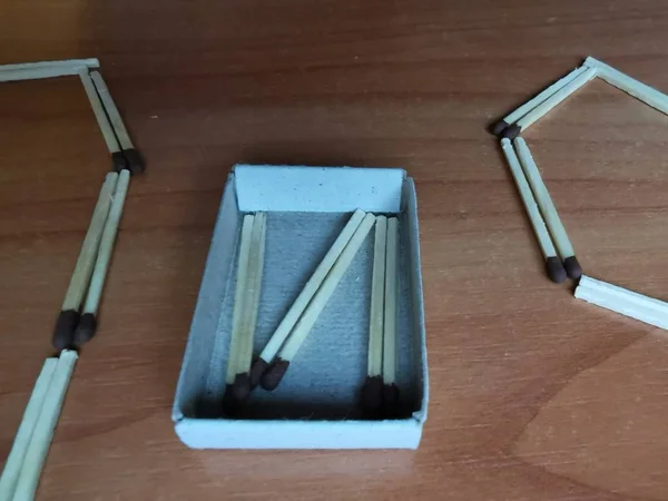 5G tie lined with matches on a wooden table