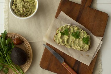 Tahta kesme tahtasındaki ton balıklı kızarmış ekmek ve avokadodan oluşan sağlıklı bir kahvaltı.