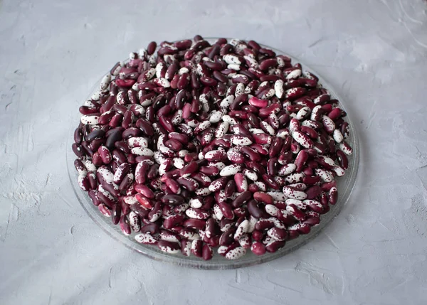 Gri arka planda beyaz ve kırmızı fasulyeler. Fasulye sağlıklı, lezzetli ve tatmin edici bir üründür..