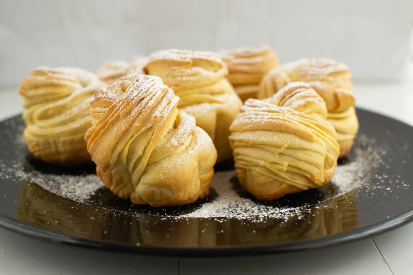 Cruffins without filling on a black plate. — Stock Photo, Image