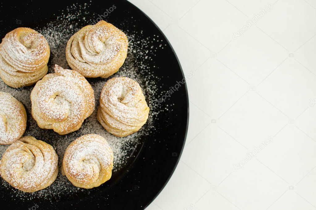 Cruffins without filling on a black plate.