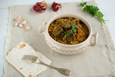 Doğu mutfağı tabağı - tavada kuzu pilav, beyaz arka planda.