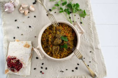 Doğu mutfağı tabağı - tavada kuzu pilav, beyaz arka planda.