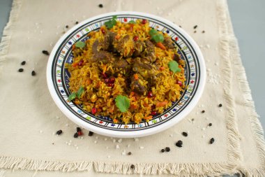 Doğu mutfağı tabağı - tavada kuzu pilav, beyaz arka planda.