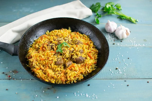 Doğu mutfağı tabağı, tavada kuzu pilavı, ahşap arka planda..