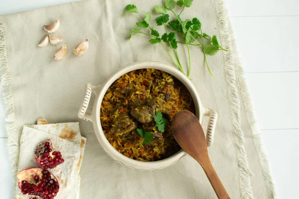 Doğu mutfağı tabağı - tavada kuzu pilav, beyaz arka planda.