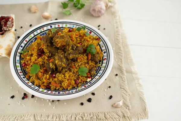 Doğu mutfağı tabağı - tavada kuzu pilav, beyaz arka planda.