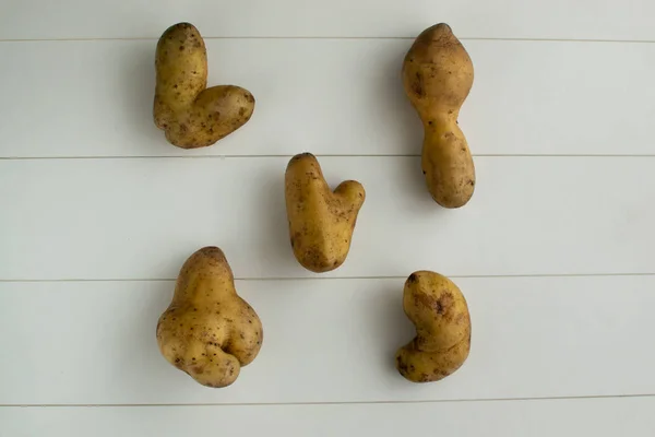 Çirkin sebzeler. Beyaz ahşap arka planda patates. en üstteki görüntü — Stok fotoğraf