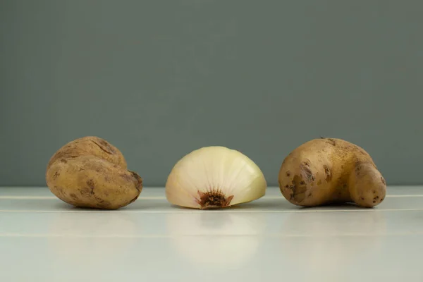 Hortalizas feas. Patatas y cebollas sobre fondo de madera blanca — Foto de Stock