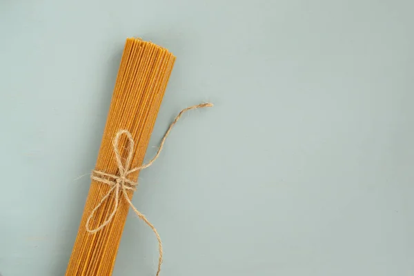Hela korn spaghetti med komplexa kolhydrater på en grå baksida — Stockfoto