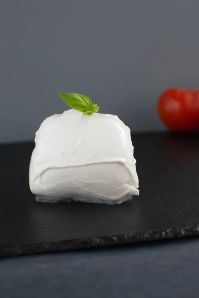 Large mozzarella with a blackened slate board. — Stock Photo, Image