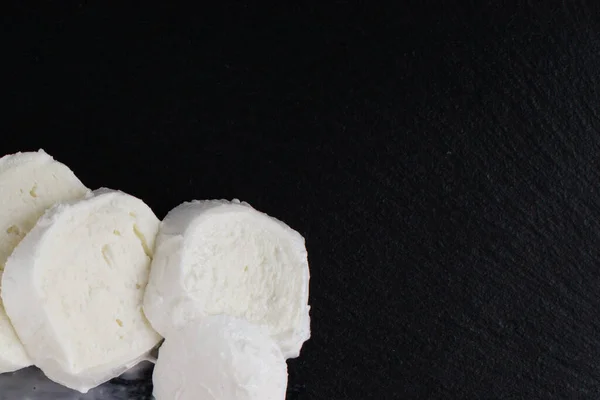 Grote mozzarella met een zwartgeblakerde leistenen plank. — Stockfoto