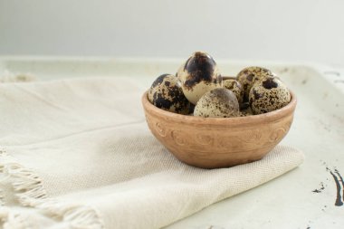 Arka planda seramik kasede bıldırcın yumurtası. Kırsal biçim.