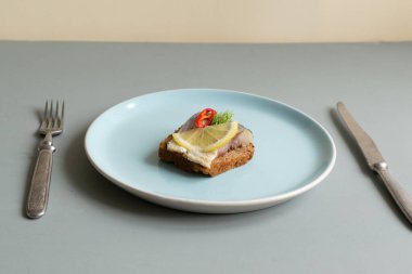 Limonlu salamura ringa balığı, acı biber ve dereotlu sandviç. Sağlıklı yiyecekler. Minimalizm. Gri arkaplan.