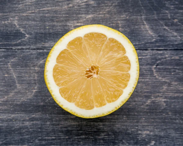 Le citron tranché repose sur une surface en bois — Photo