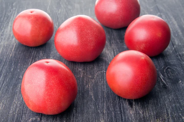 Kilka dojrzałych pomidorów, leżącego na powierzchni drewnianych — Zdjęcie stockowe