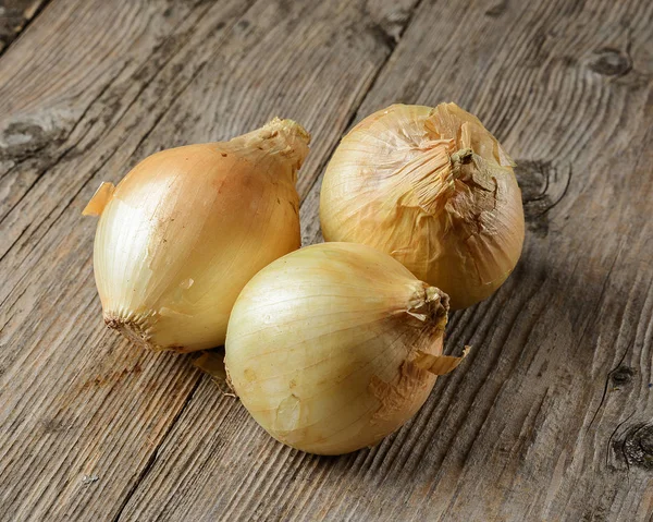 Tres Cebollas Sobre Una Superficie Madera — Foto de Stock