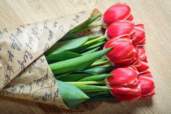 Buquê envolto de tulipas em um jornal — Fotografia de Stock